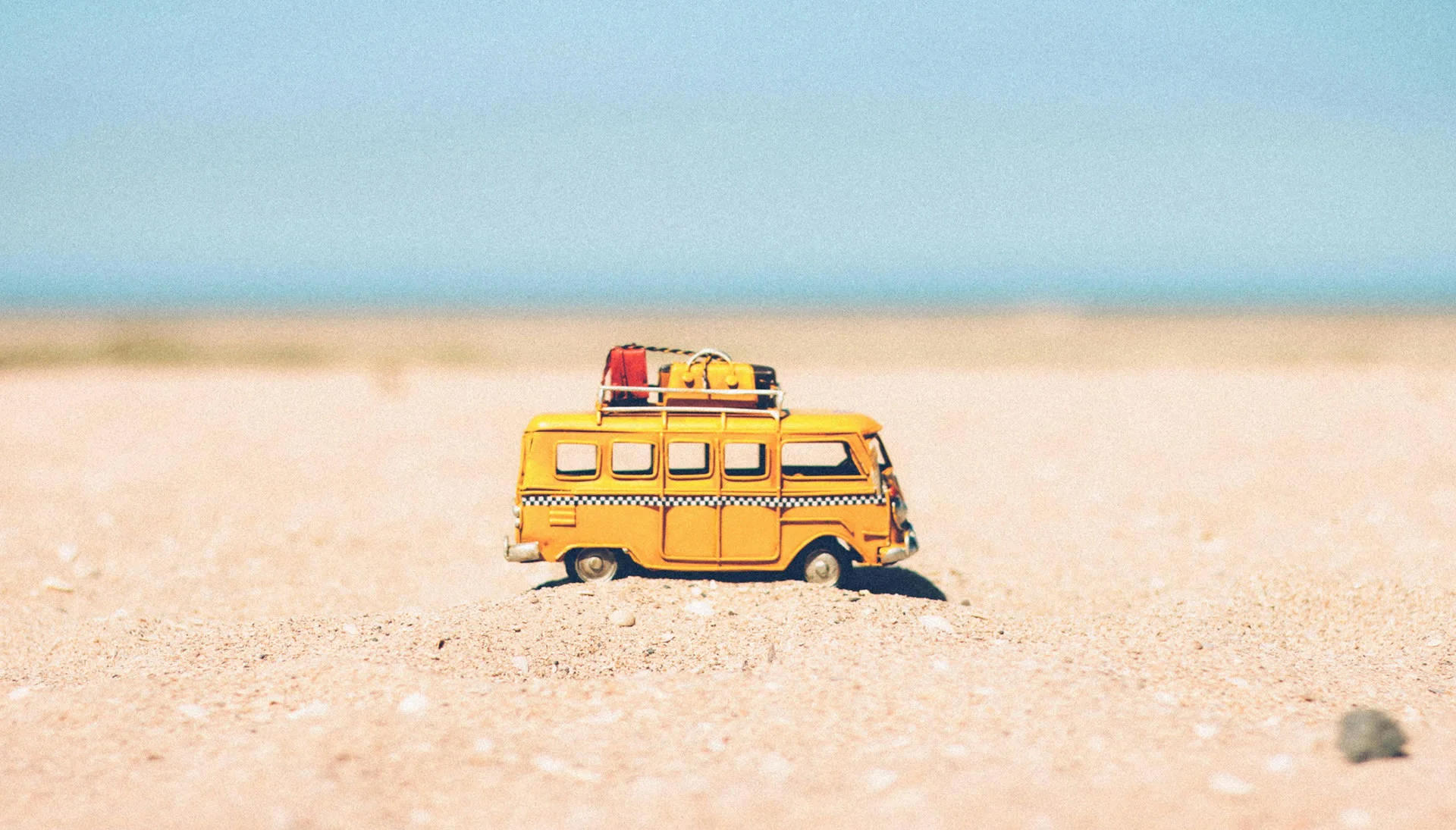 Yellow Die-cast Miniature Van on Brown Sand